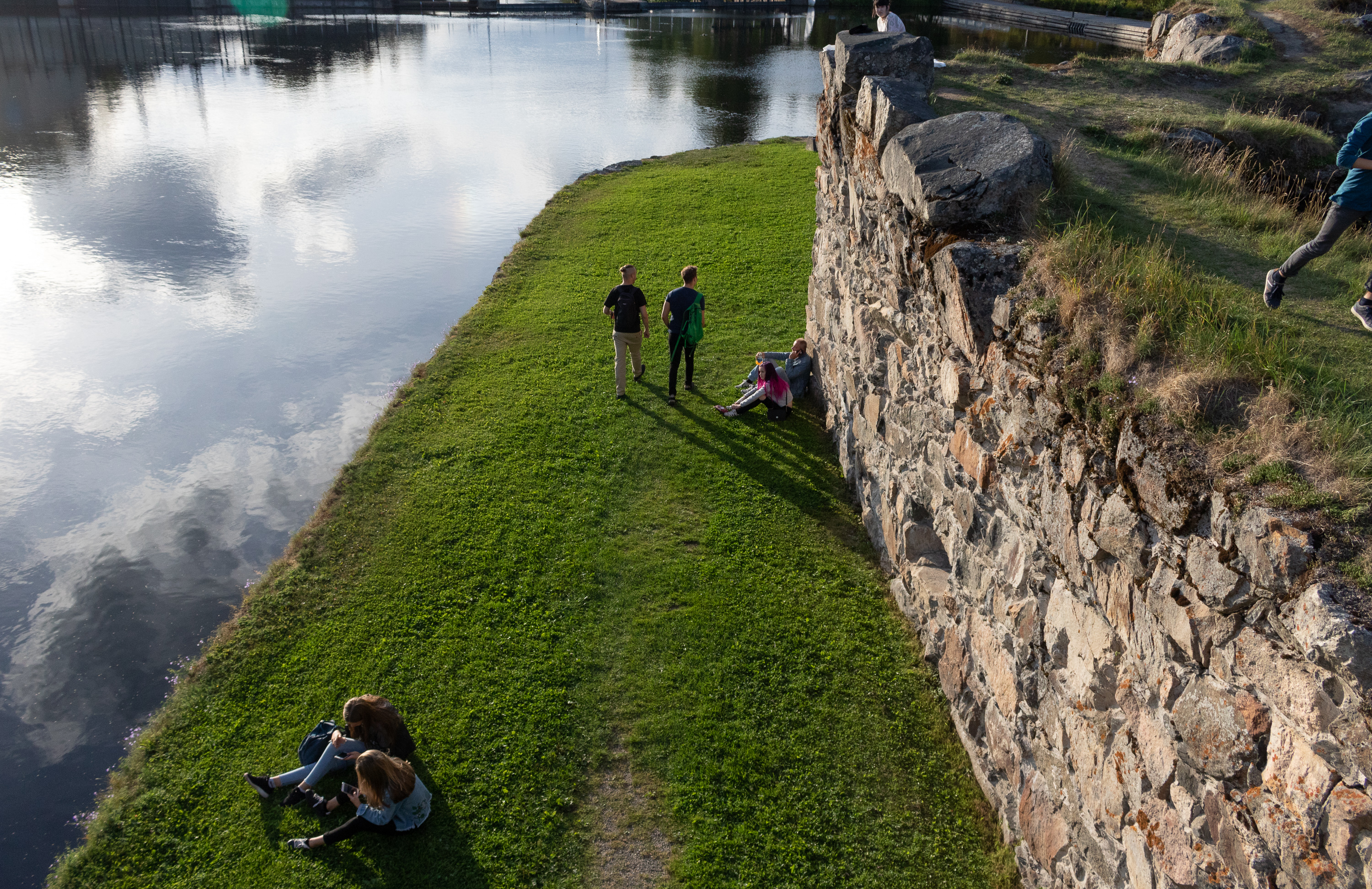 Ihmisiä kesäillassa Kajaanin Linnan raunioilla 