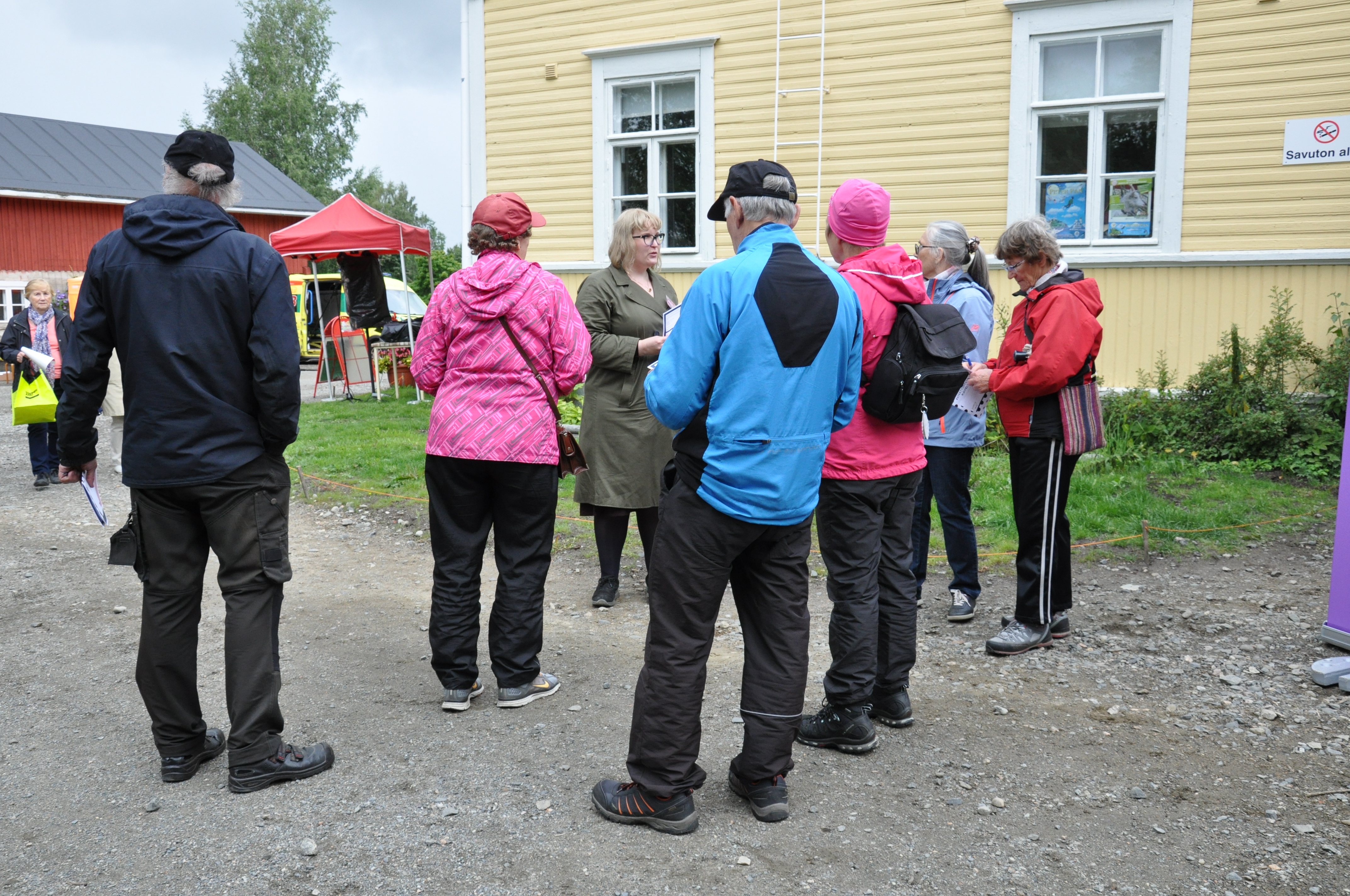Photograph of the project coordinator speaking to a group of six people taking part in the accessibility walk