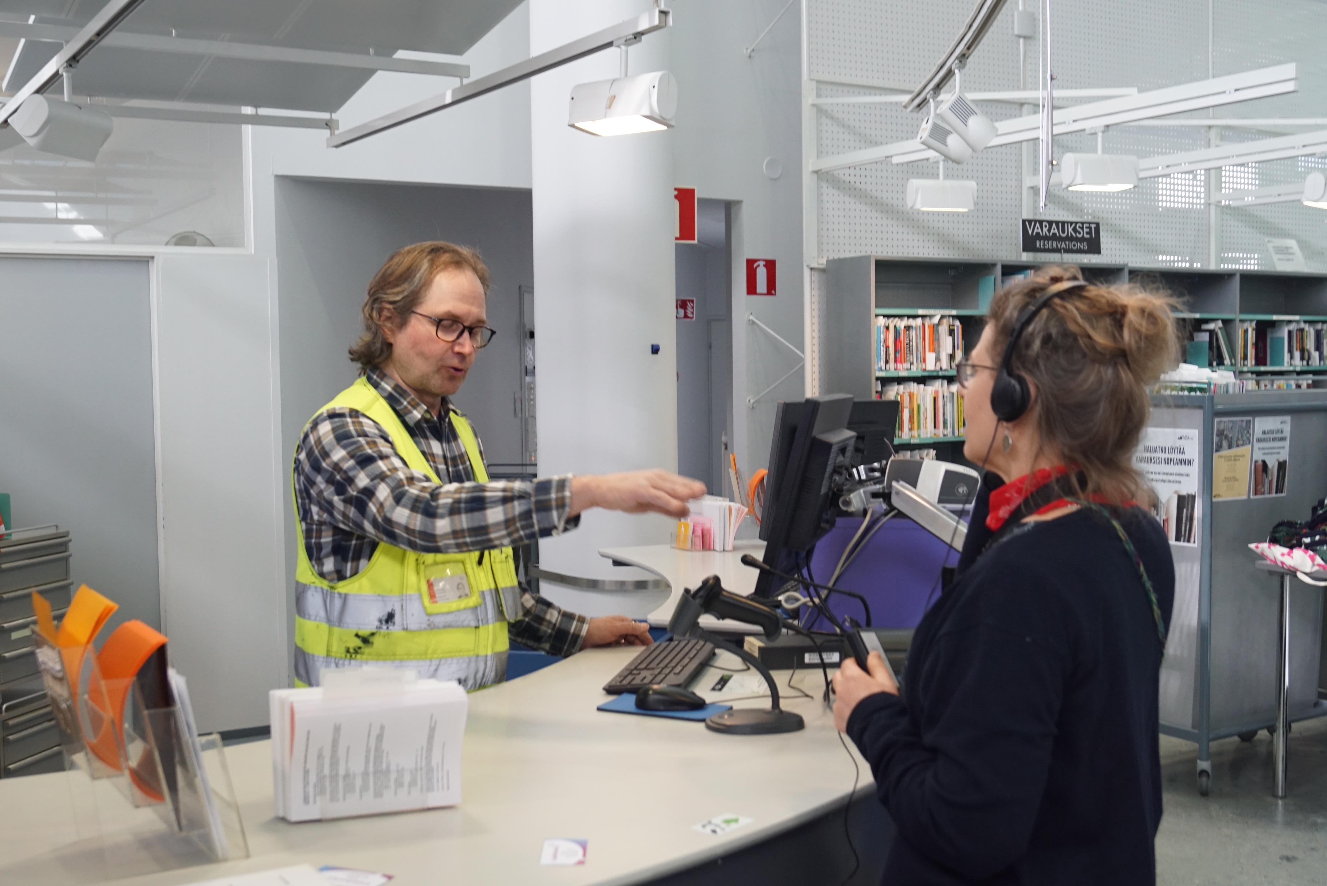 Ari Törmä shows member of library staff how the induction loop works